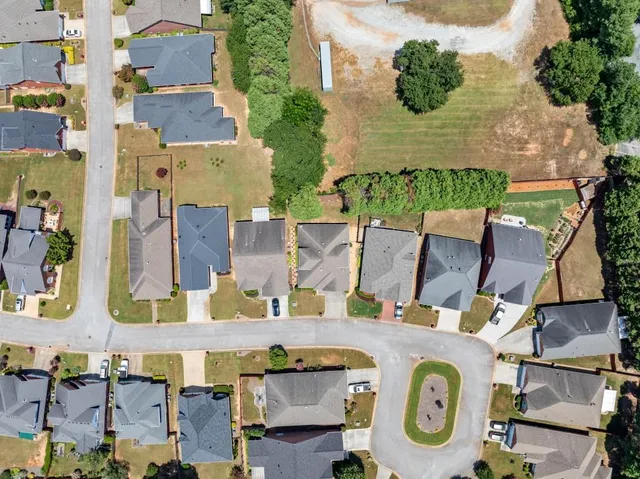 a kitchen with stainless steel appliances granite countertop a table chairs refrigerator and sink