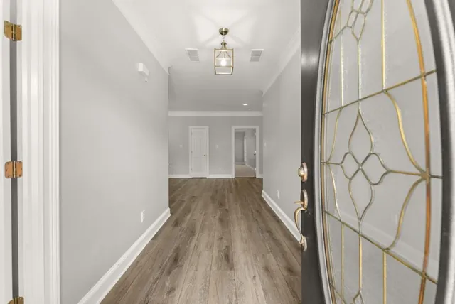 a view of a hallway with wooden floor and staircase