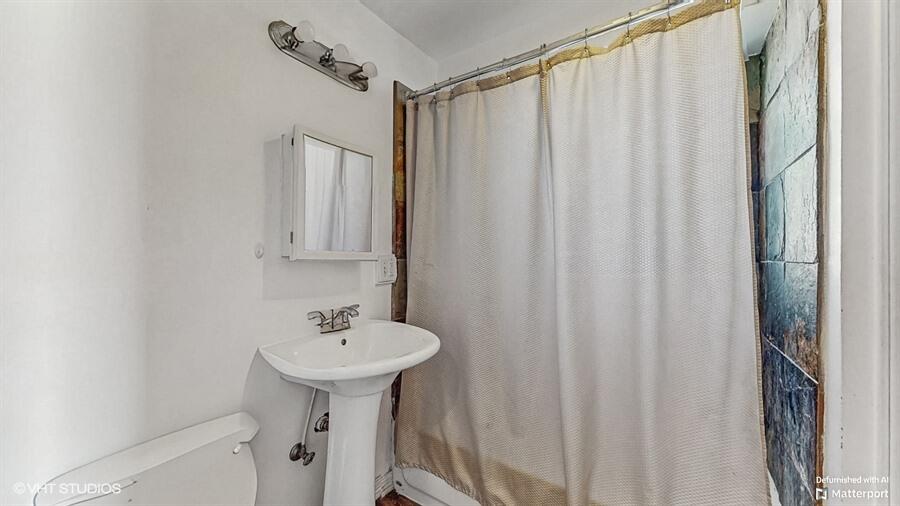 2140 Indianapolis Boulevard Whiting, IN 46394 - Photo 17 of 63 a bathroom with a sink a mirror and a shower curtain