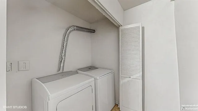 a view of a room with wooden floor electronic appliances and windows