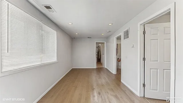 a view of a hallway with wooden floor and closet