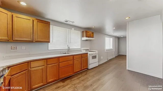 a large kitchen with stainless steel appliances granite countertop a sink and cabinets with wooden floor