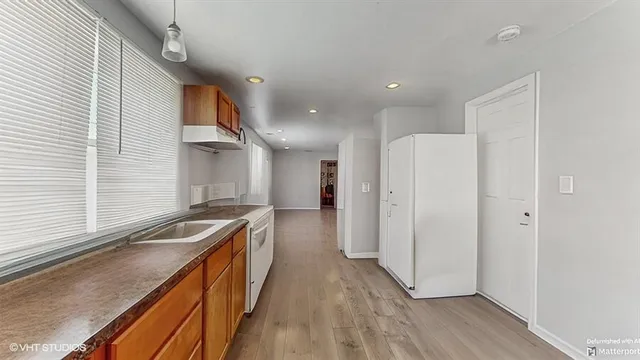 a kitchen with stainless steel appliances granite countertop a sink a stove and a refrigerator