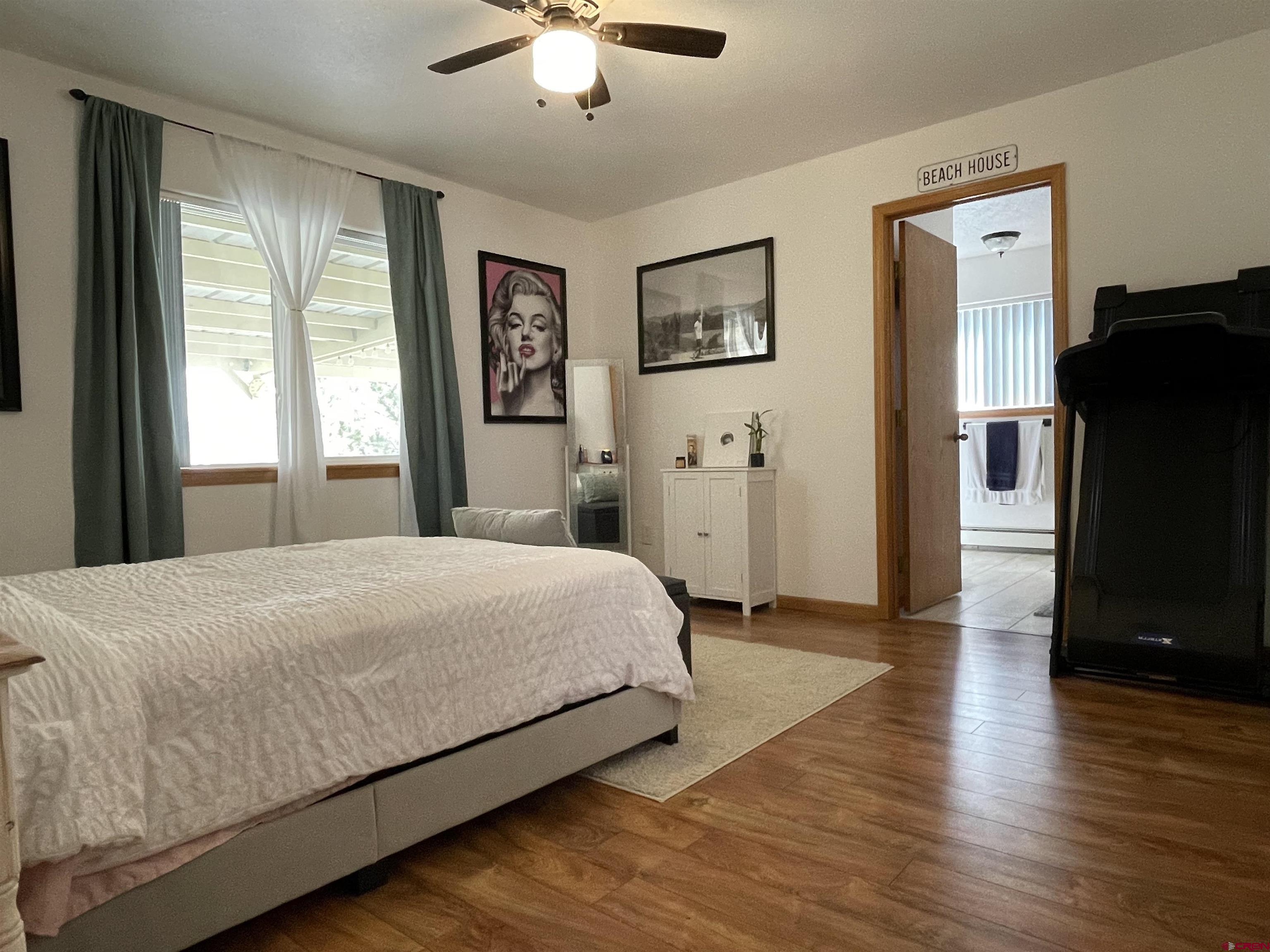 8902 6085 Road Montrose, CO 81401 - Photo 11 of 31 a bedroom with a bed and a chandelier