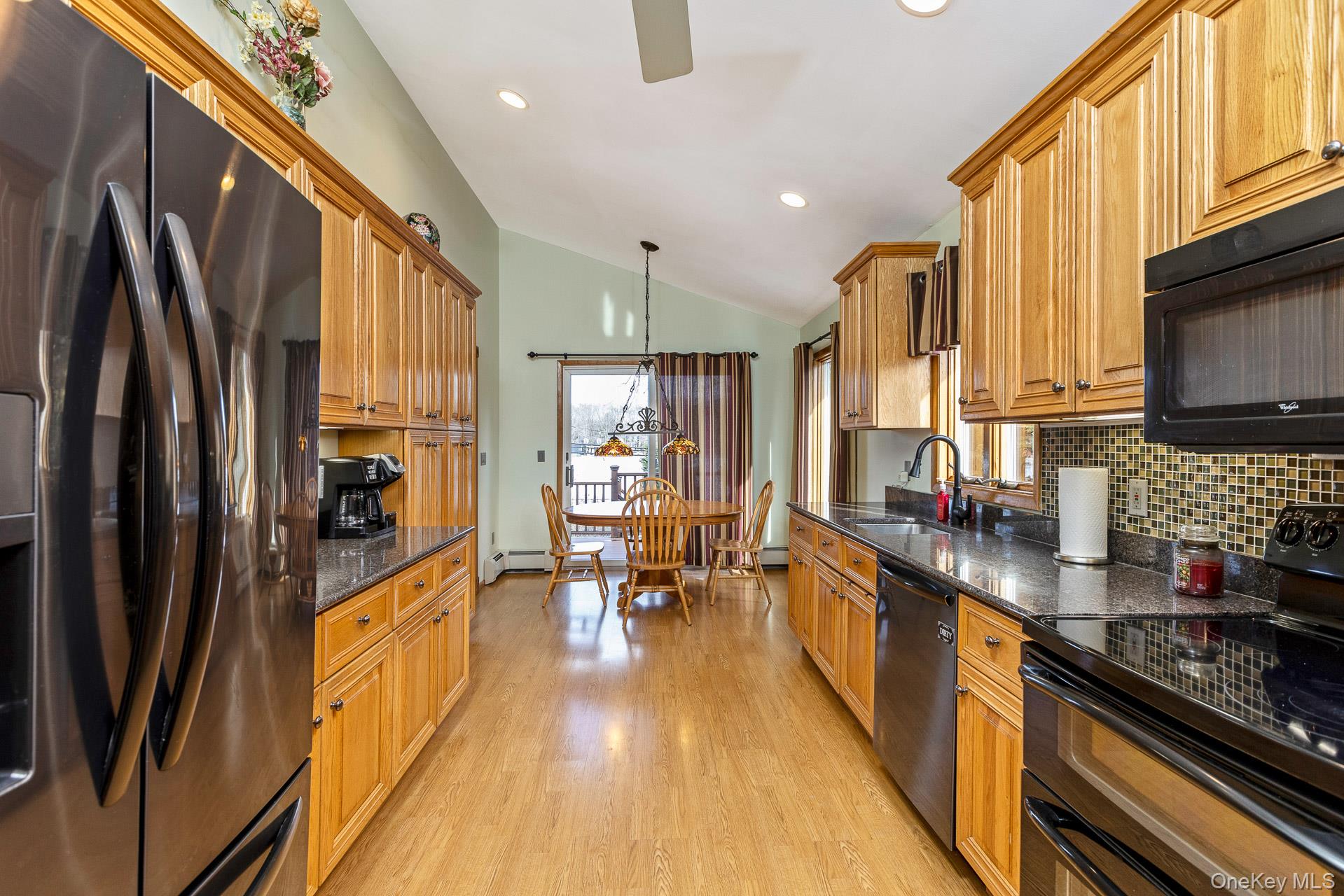 173 Fifty Acre Road South Smithtown, NY 11787 - Photo 19 of 42 a kitchen with stainless steel appliances a refrigerator a stove a sink dishwasher a stove and a dining table with wooden floor