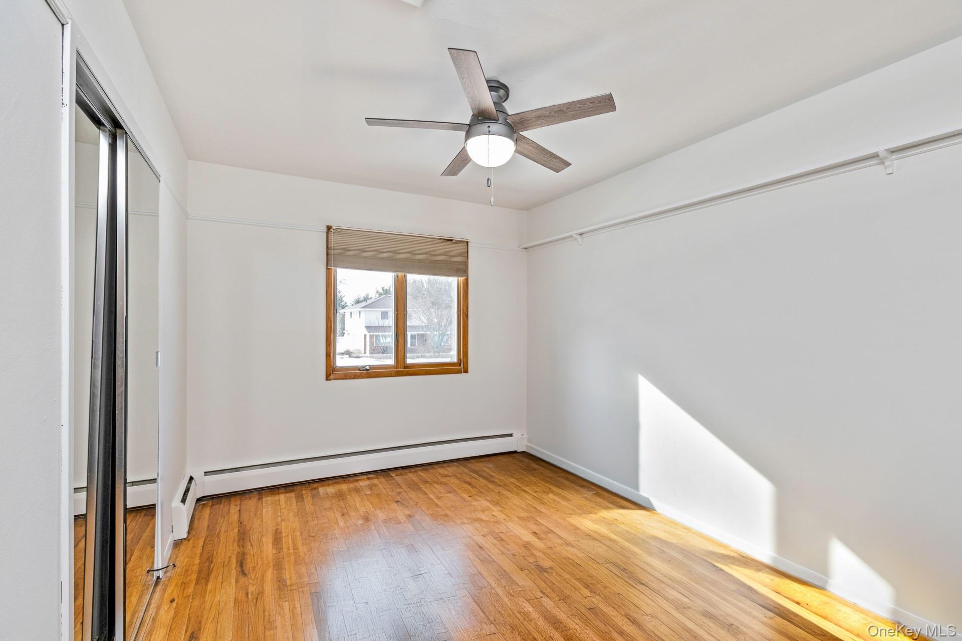 173 Fifty Acre Road South Smithtown, NY 11787 - Photo 22 of 42 a view of an empty room with a window and wooden floor