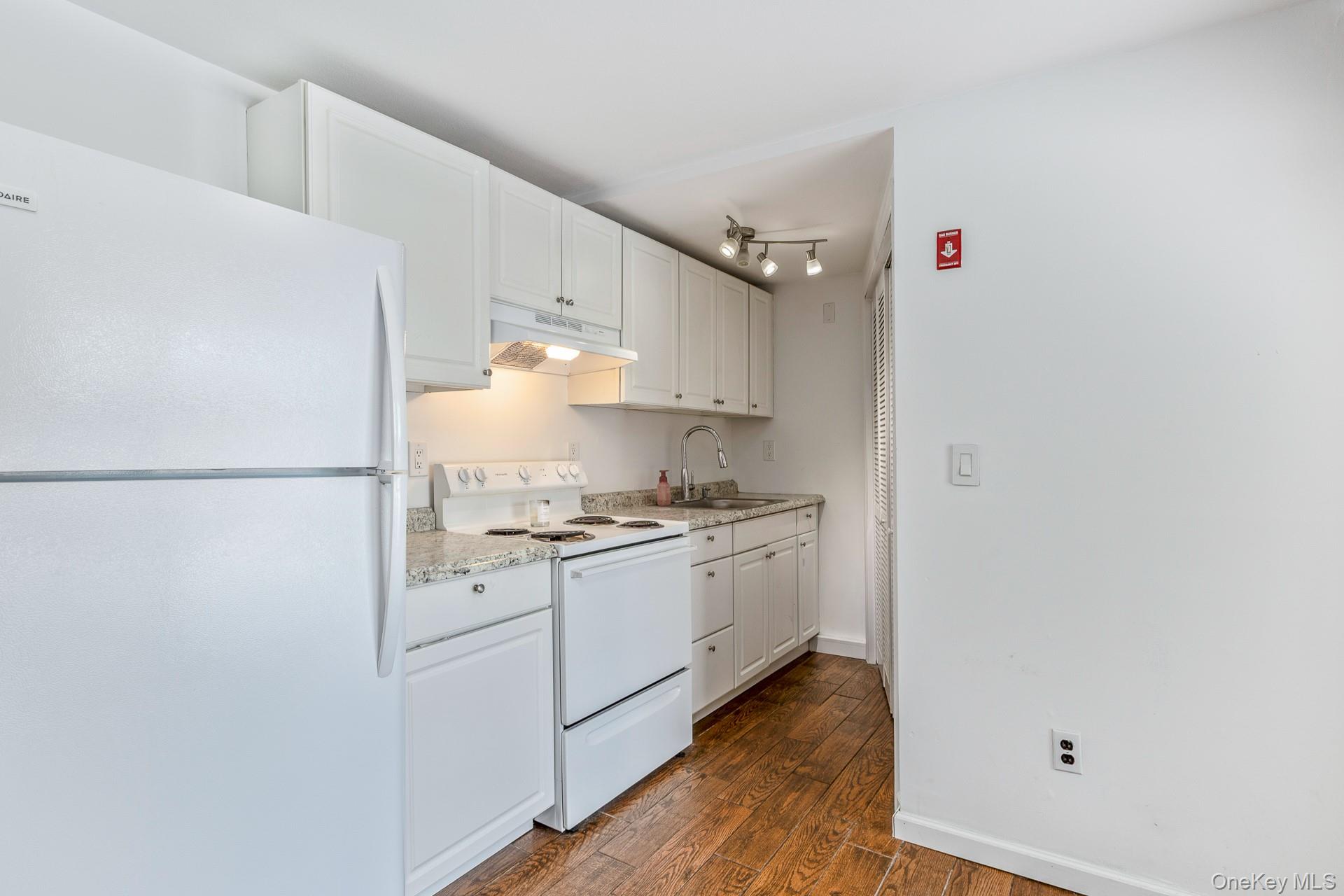 173 Fifty Acre Road South Smithtown, NY 11787 - Photo 30 of 42 a kitchen with a sink cabinets and wooden floor