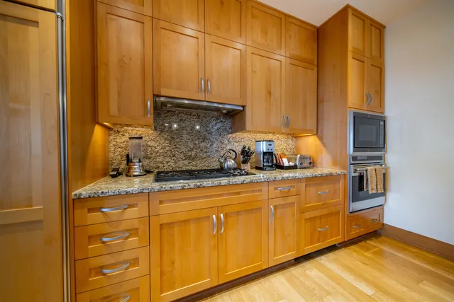 a kitchen with stainless steel appliances granite countertop a stove a sink and a refrigerator