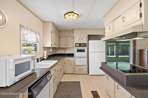 a kitchen with stainless steel appliances granite countertop a sink a stove and a refrigerator