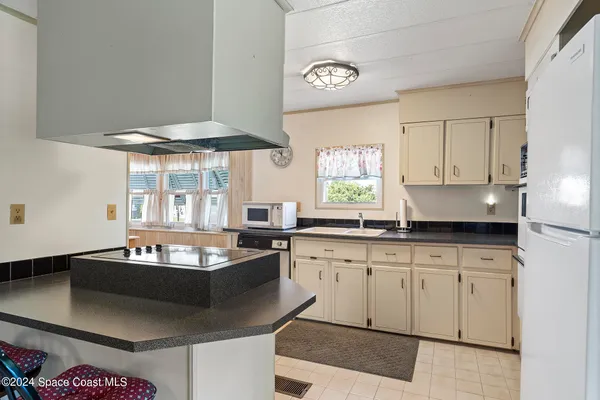 a kitchen with granite countertop a sink a stove and cabinets
