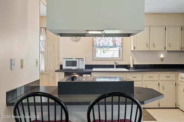 a kitchen with stainless steel appliances granite countertop a stove a sink dishwasher and white cabinets with wooden floor