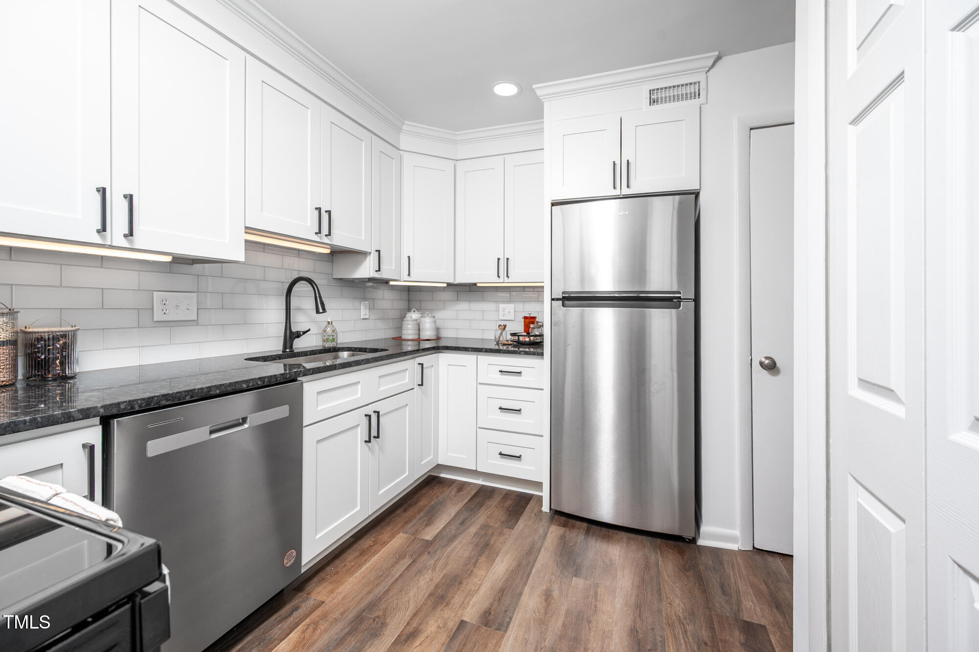 906 Oak Tree Drive Chapel Hill, NC 27517 - Photo 8 of 22 a kitchen with white cabinets stainless steel appliances and a refrigerator