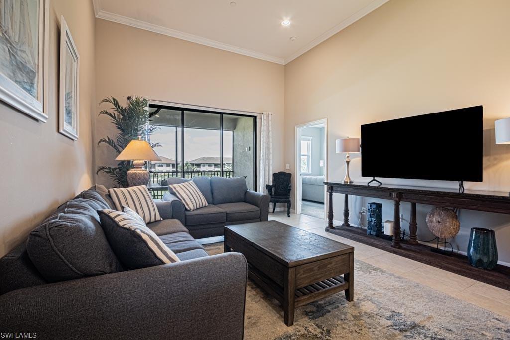 9378 Pocida Court, Unit 202 Naples, FL 34119 - Photo 22 of 41 a living room with furniture and a flat screen tv