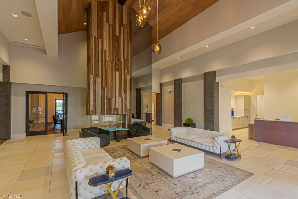 9378 Pocida Court, Unit 202 Naples, FL 34119 - Photo 30 of 42 Reception area of the Barrel House with floor to ceiling fireplace, wine lockers, & dining room