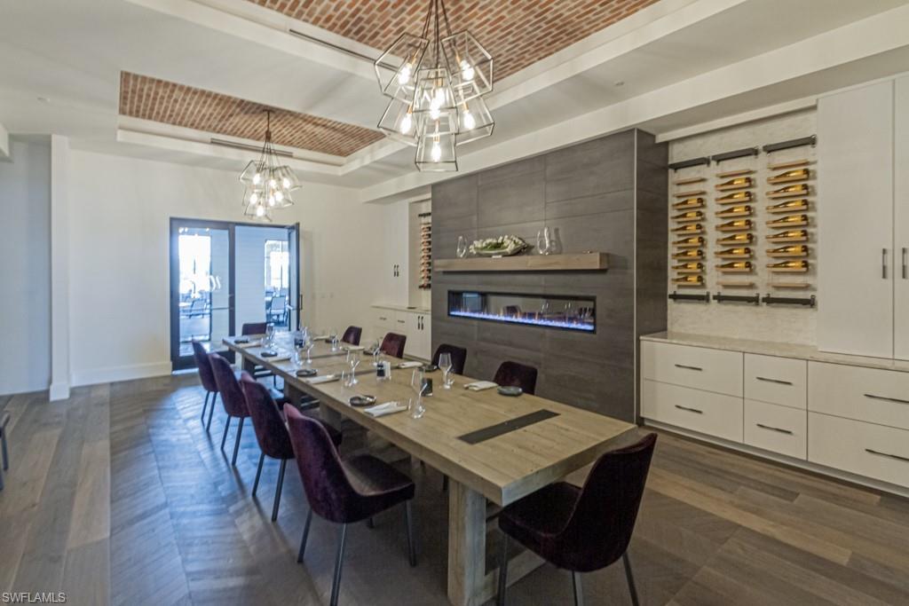 9378 Pocida Court, Unit 202 Naples, FL 34119 - Photo 30 of 41 a view of a dining room with furniture wooden floor and chandelier