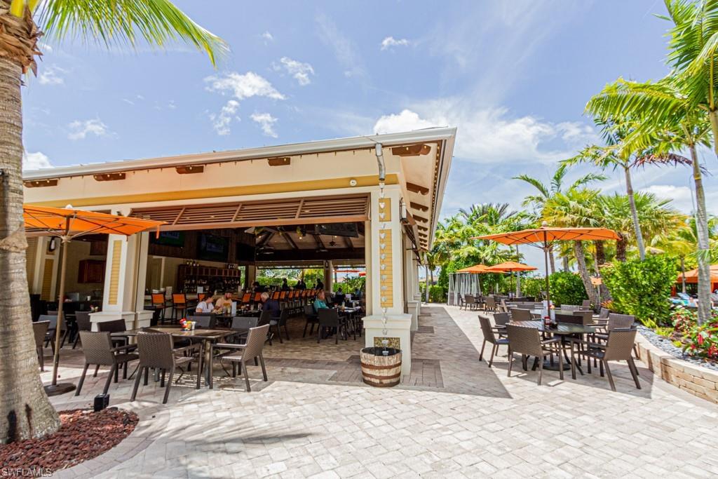 9378 Pocida Court, Unit 202 Naples, FL 34119 - Photo 36 of 41 a view of a patio with a table and chairs under an umbrella