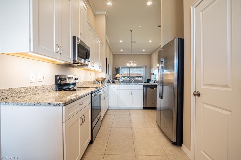 9378 Pocida Court, Unit 202 Naples, FL 34119 - Photo 6 of 41 a kitchen with stainless steel appliances granite countertop a refrigerator sink and cabinets