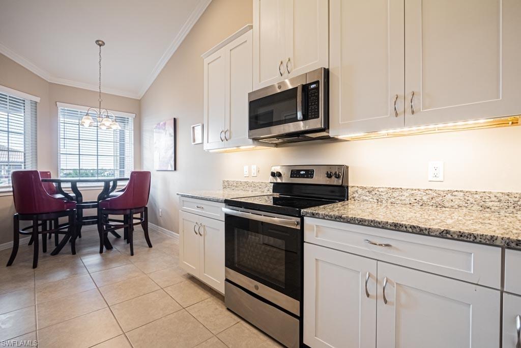 9378 Pocida Court, Unit 202 Naples, FL 34119 - Photo 8 of 41 a kitchen with stainless steel appliances granite countertop white cabinets granite counter tops and a hard wood floors