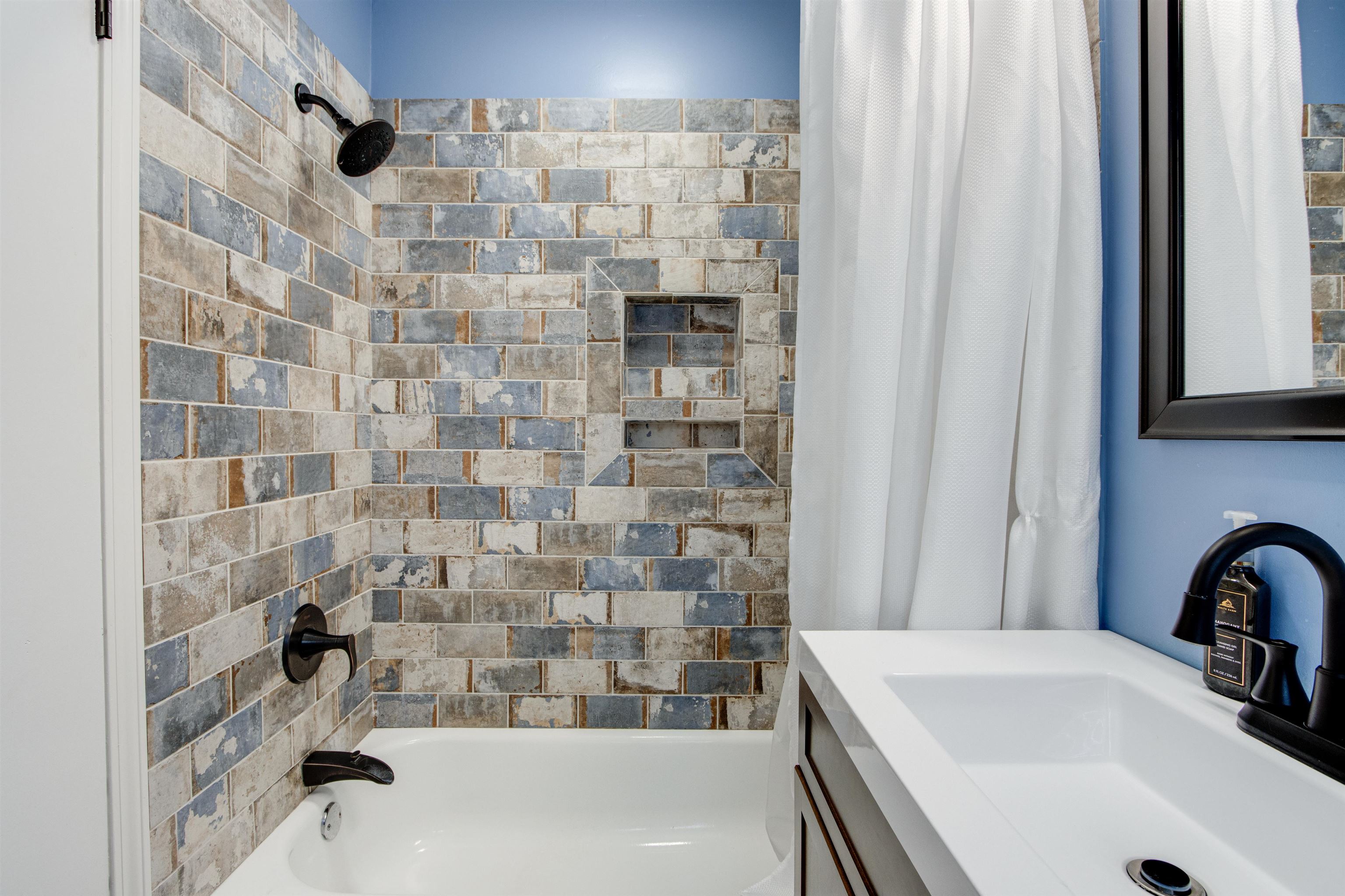 359 South Fenwick Road Memphis, TN 38111 - Photo 15 of 31 Bathtub and shower combination featuring distressed subway tile surround with integrated niche