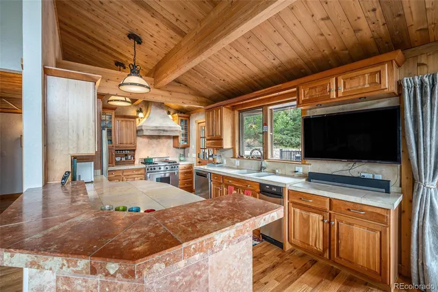 a open kitchen with stainless steel appliances granite countertop a sink a counter space cabinets and furniture