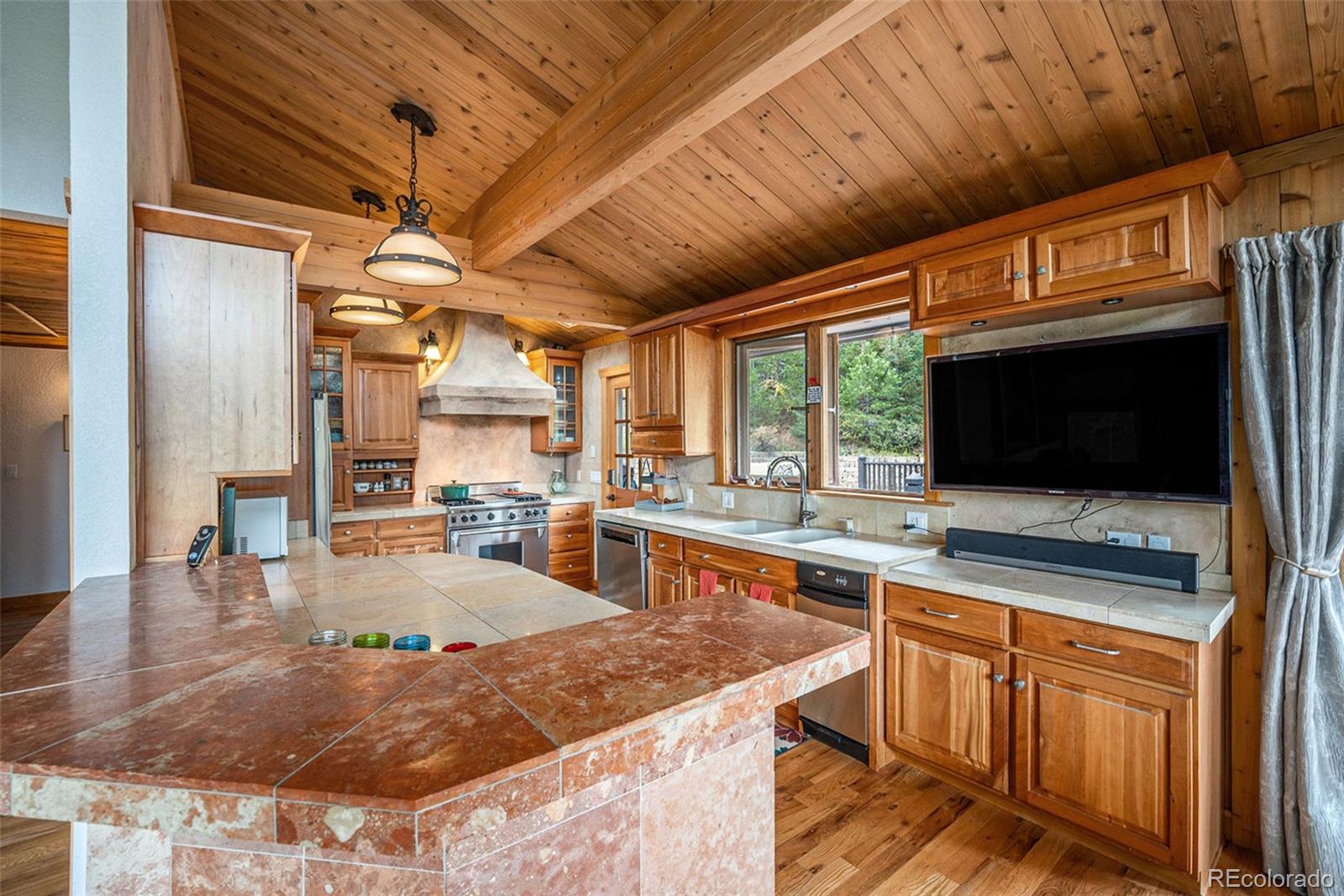 1774 Upper Bear Creek Road Evergreen, CO 80439 - Photo 12 of 43 a open kitchen with stainless steel appliances granite countertop a sink a counter space cabinets and furniture