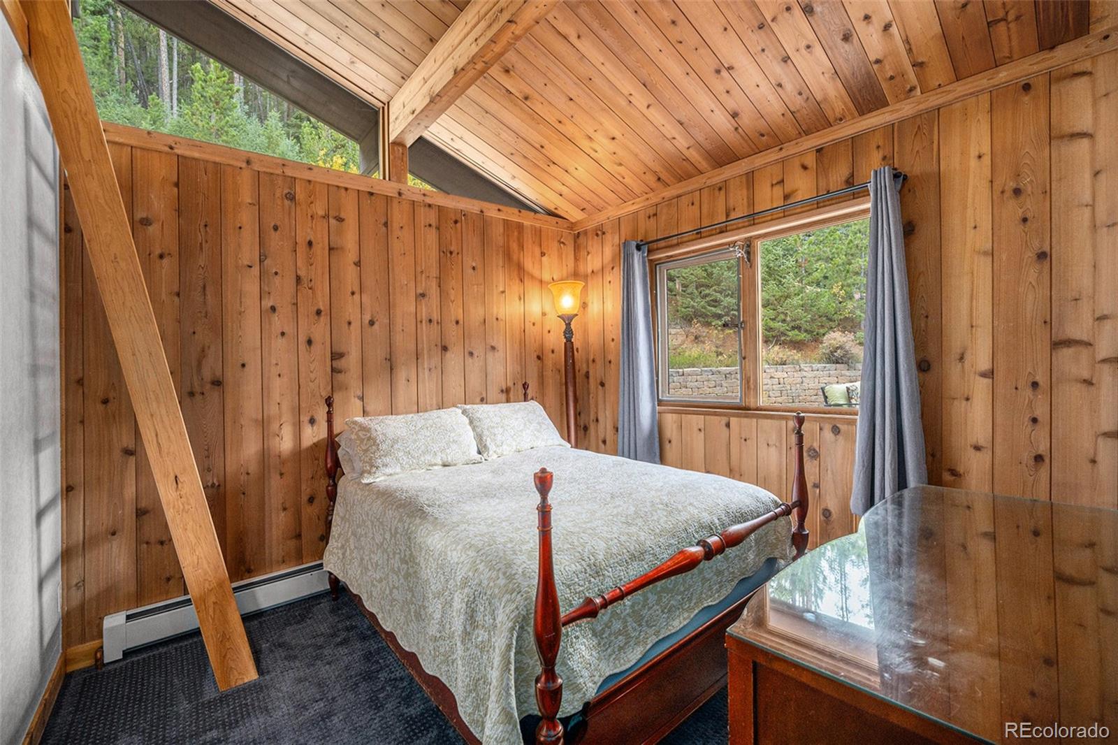 1774 Upper Bear Creek Road Evergreen, CO 80439 - Photo 20 of 43 a bed sitting in a bedroom next to a window