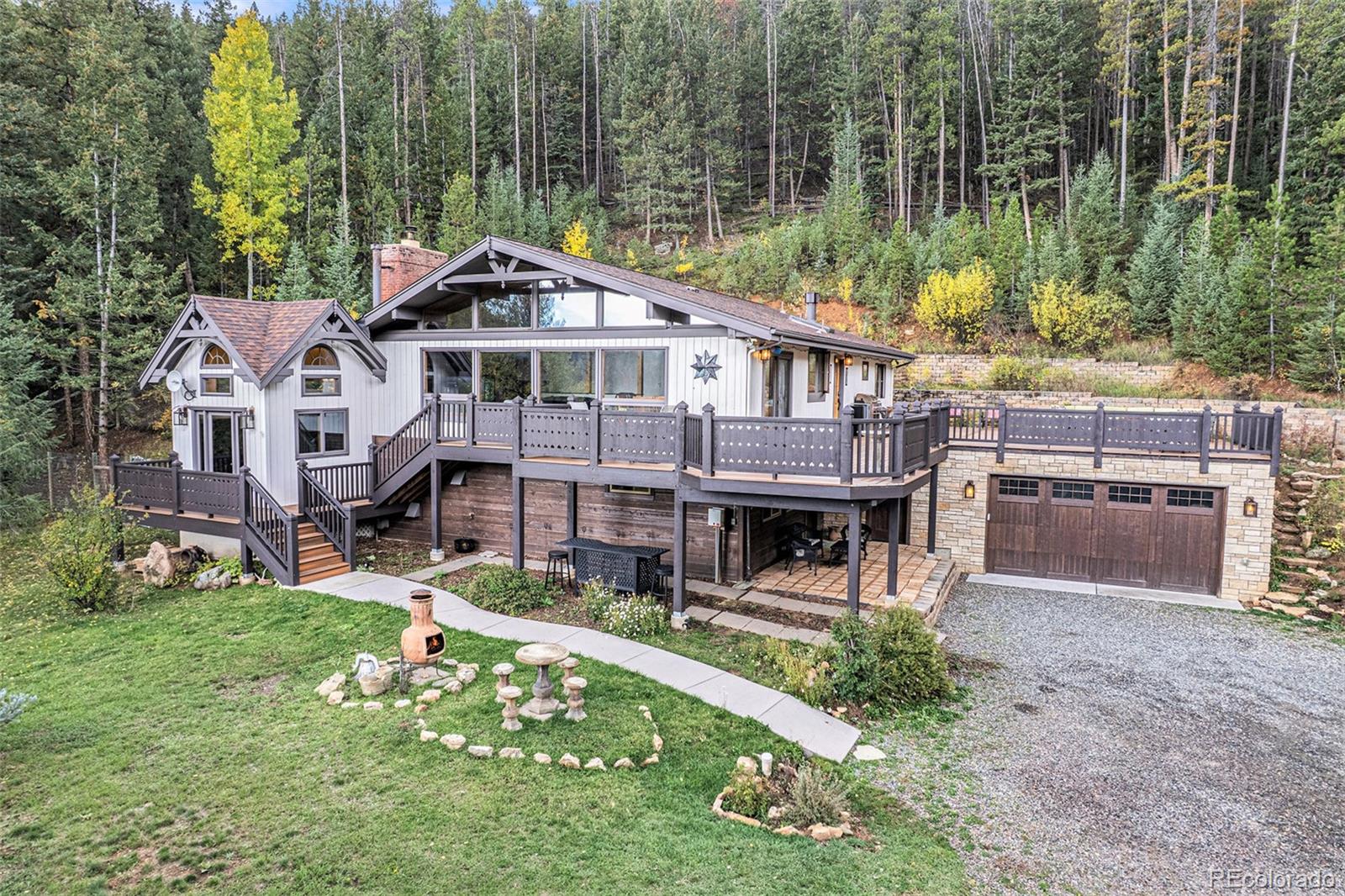 1774 Upper Bear Creek Road Evergreen, CO 80439 - Photo 2 of 43 a front view of a house with garden