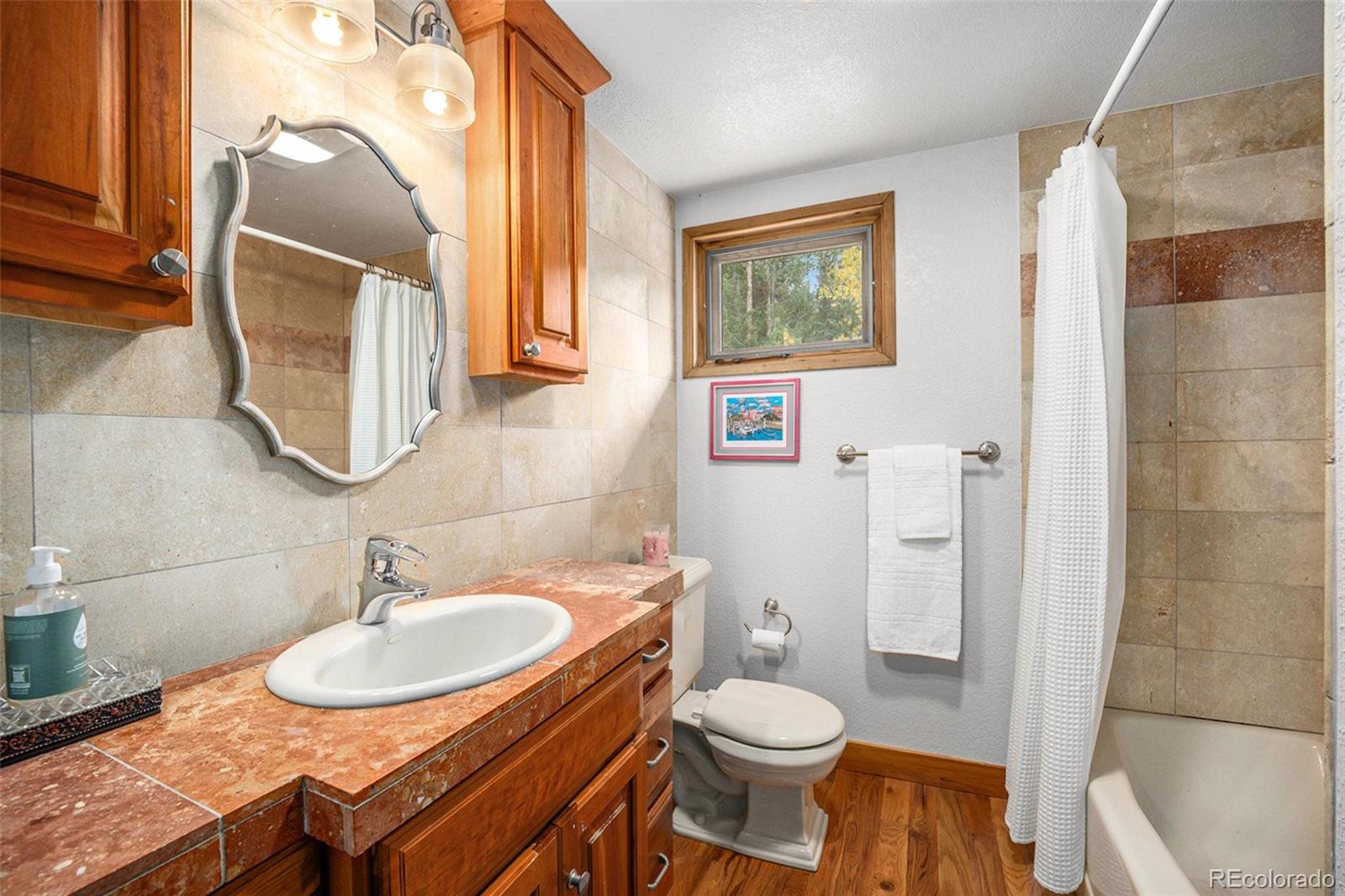 1774 Upper Bear Creek Road Evergreen, CO 80439 - Photo 22 of 43 a bathroom with a granite countertop sink and a mirror