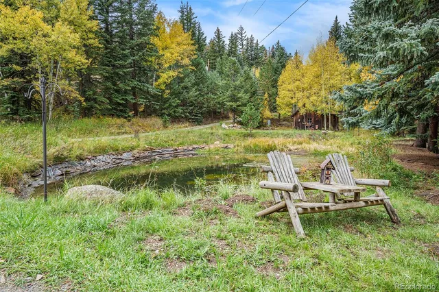 a view of a lake with a bench and trees