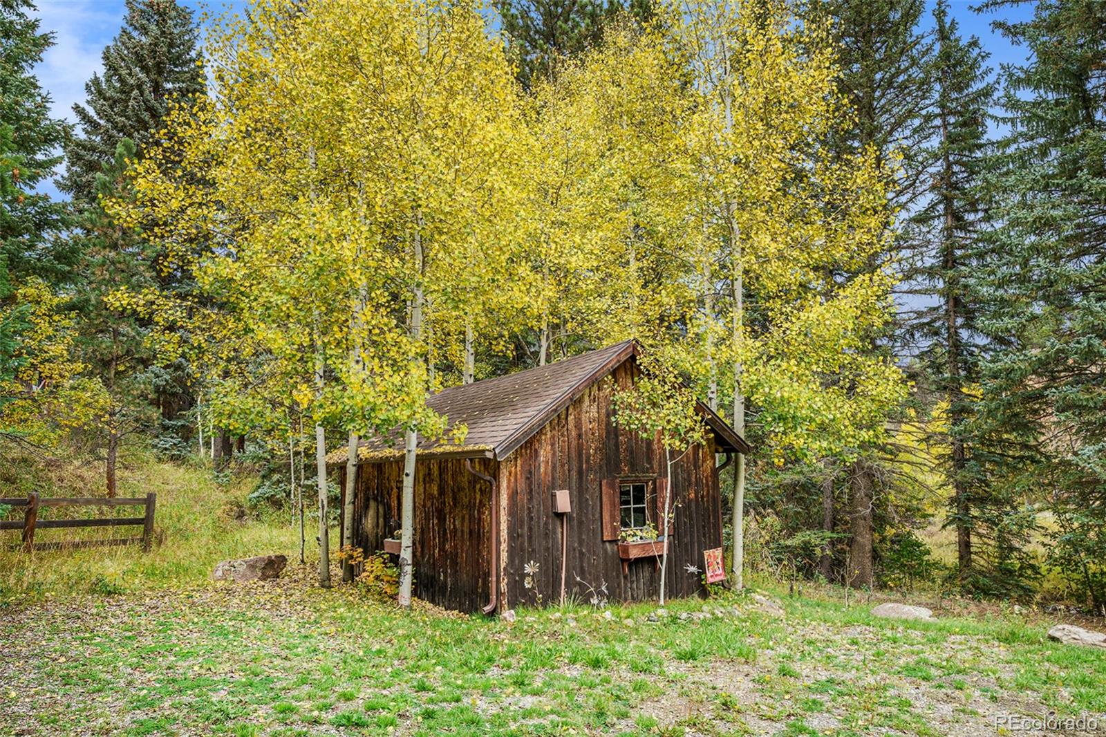1774 Upper Bear Creek Road Evergreen, CO 80439 - Photo 42 of 43 a backyard of a house with lots of plants and tree