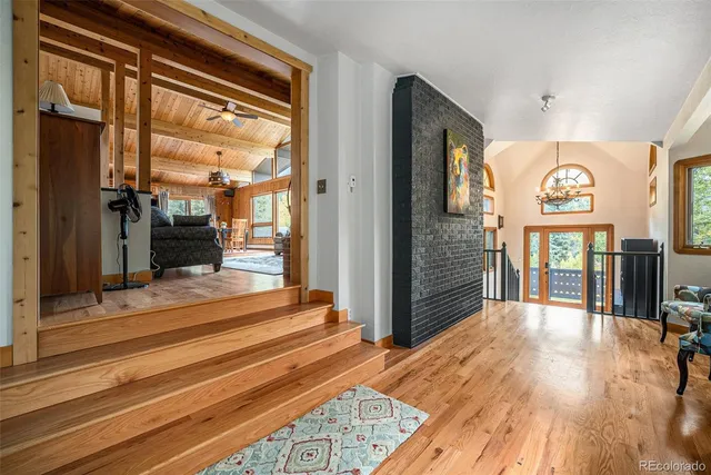 a view of a hallway with wooden floor and staircase
