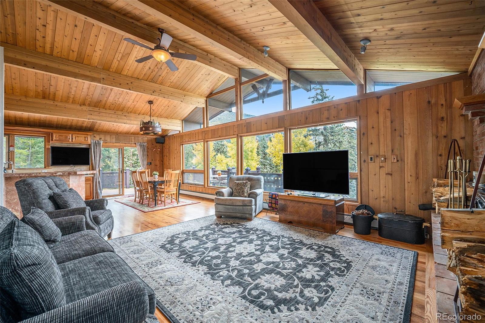 1774 Upper Bear Creek Road Evergreen, CO 80439 - Photo 7 of 43 a living room with furniture and a flat screen tv