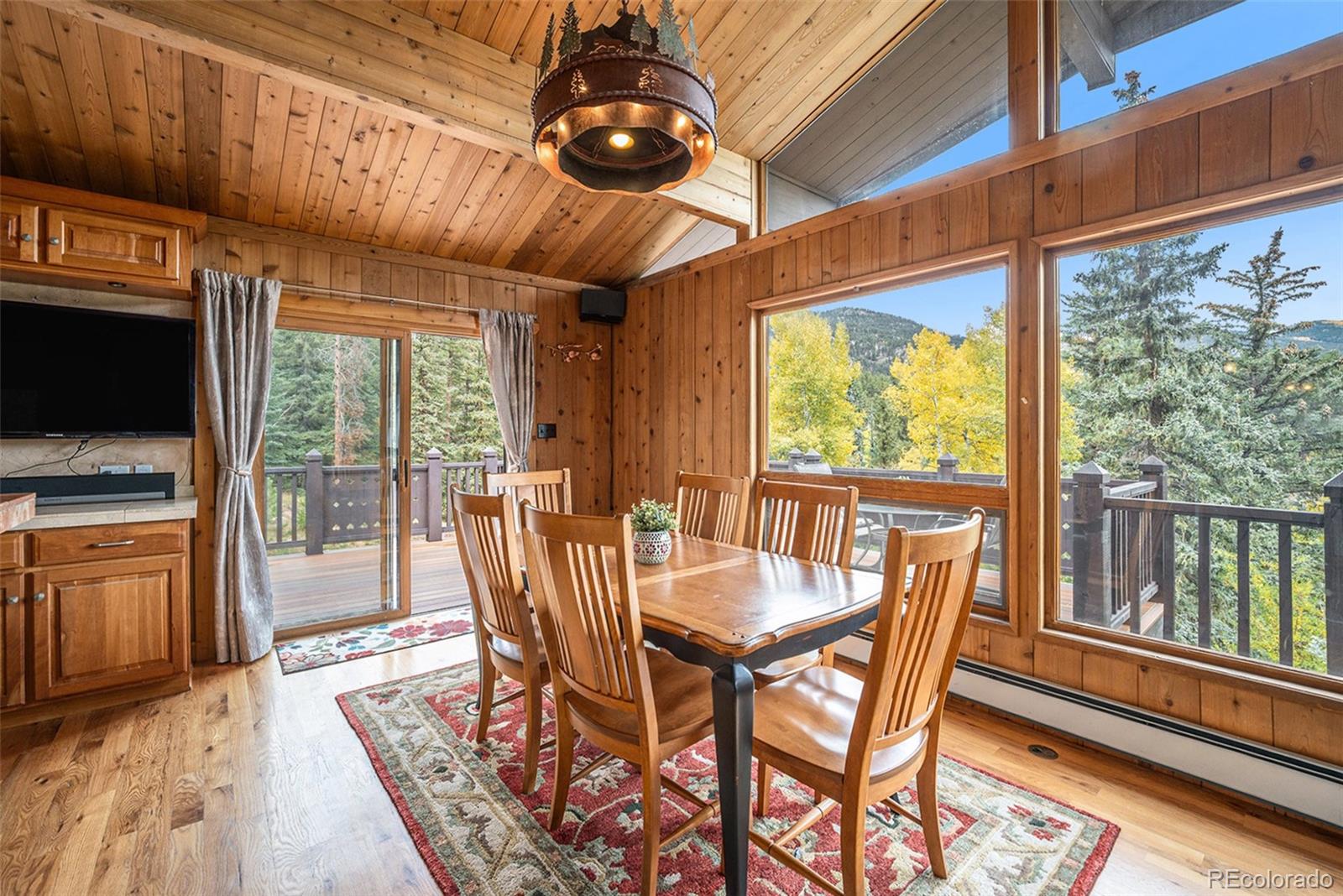 1774 Upper Bear Creek Road Evergreen, CO 80439 - Photo 9 of 43 a dining room with furniture a chandelier and wooden floor