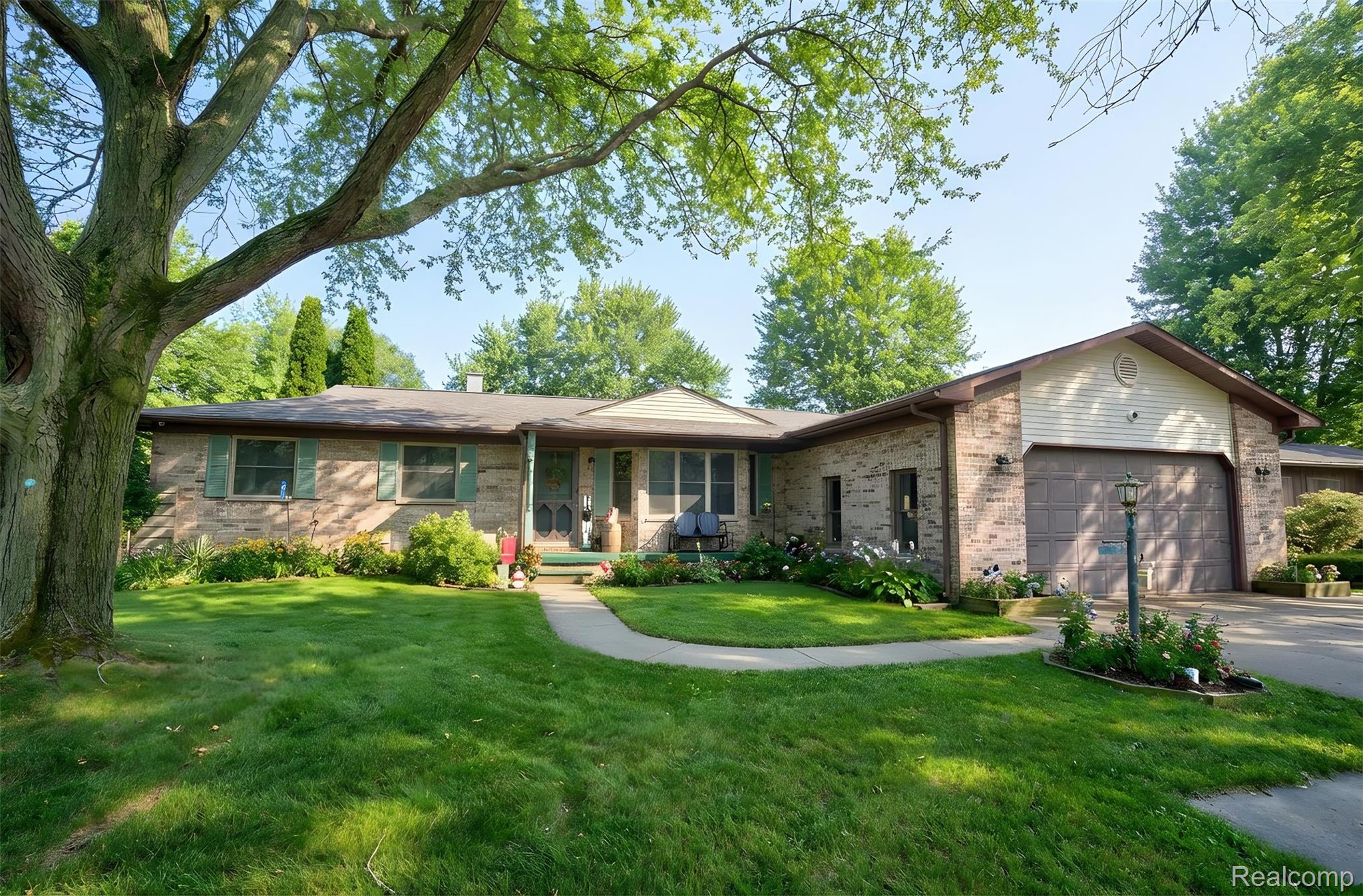 6076 East Carpenter Road Flint, MI 48506 - Photo 1 of 67 Ranch-style home with brick siding, a garage, a front lawn, and driveway