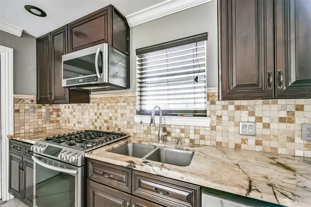 a bathroom with a granite countertop sink a toilet and mirror