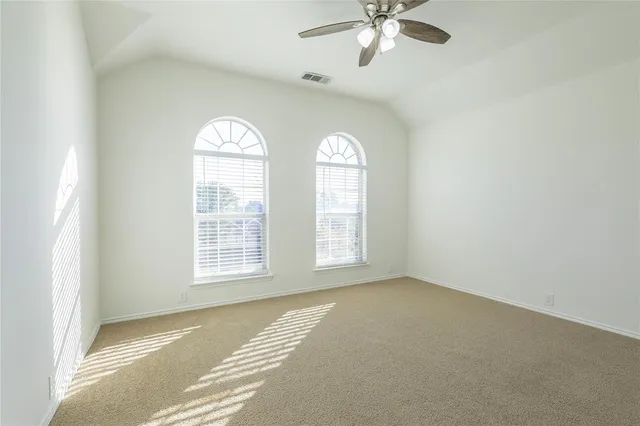 an empty room with windows and fan