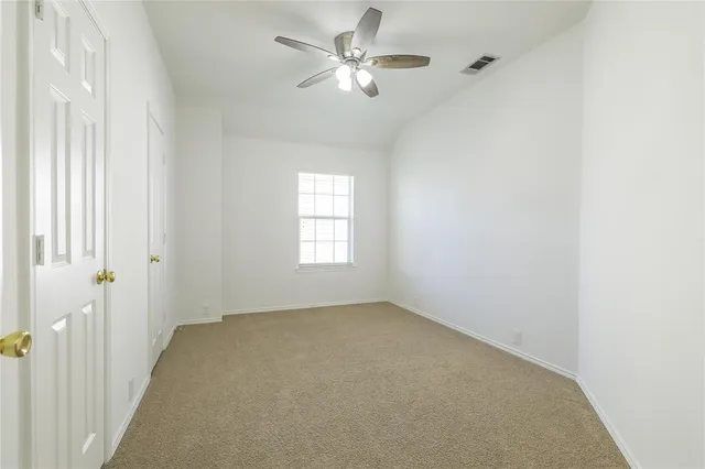 a view of a room with a ceiling fan and a window