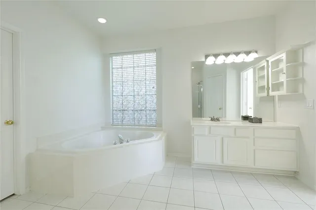 a bathroom with a bathtub sink and mirror