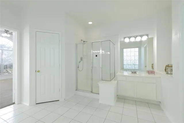 a spacious bathroom with a mirror a shower and a sink