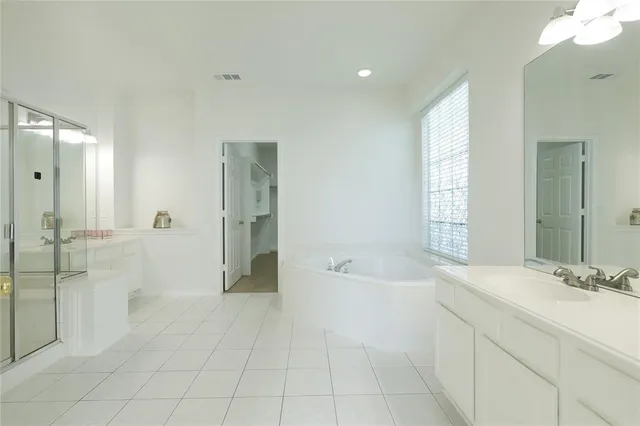 a spacious bathroom with a bathtub sink and mirror
