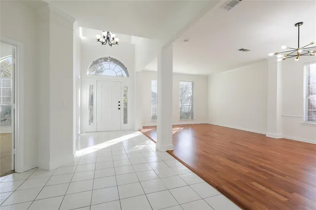 a view of empty room with window and wooden floor