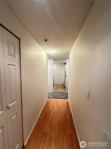 a view of a room with wooden floor and a hallway
