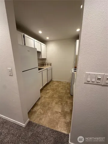 a view of a refrigerator in kitchen and wooden floor