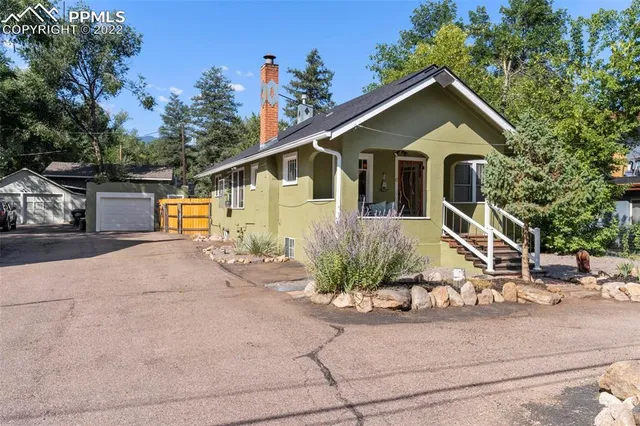 a view of a house with a yard and potted plants