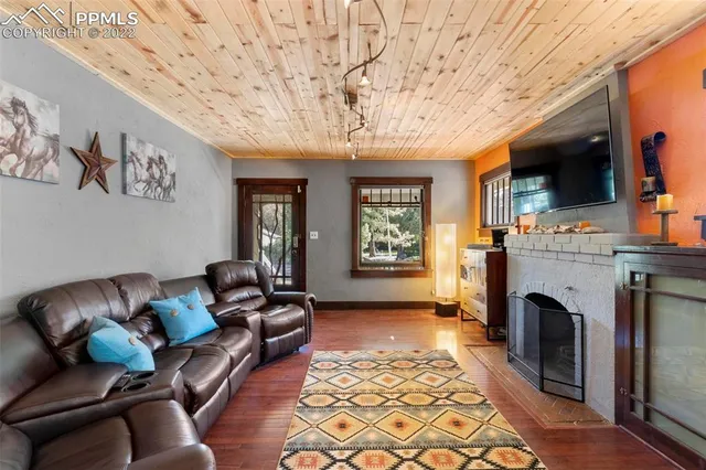 a living room with furniture a fireplace and a flat screen tv