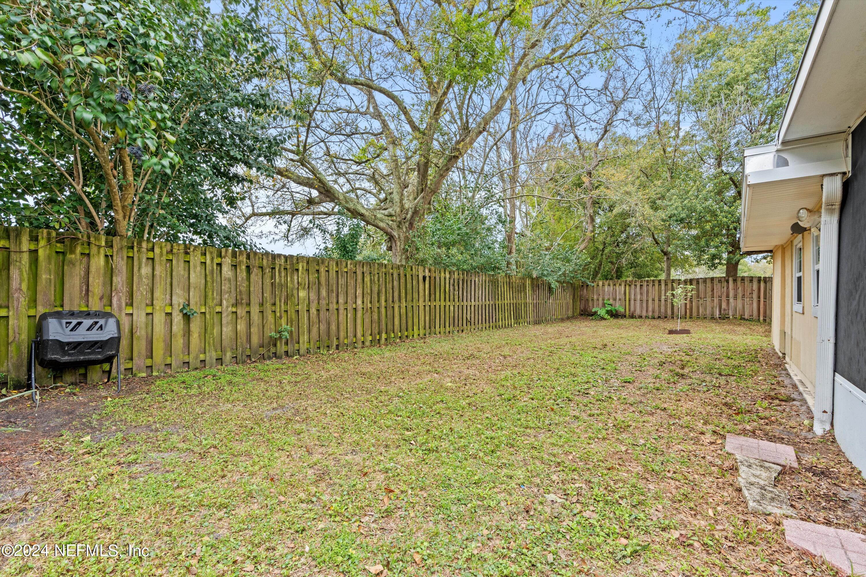 10750 Java Drive Jacksonville, FL 32246 - Photo 21 of 23 a backyard of a house with a large tree and wooden fence