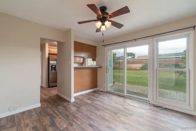 a view of a livingroom with a ceiling fan and window