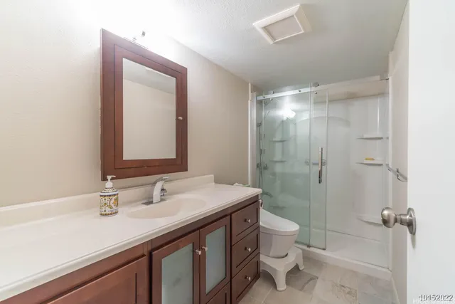 a bathroom with a sink a toilet a shower and a mirror