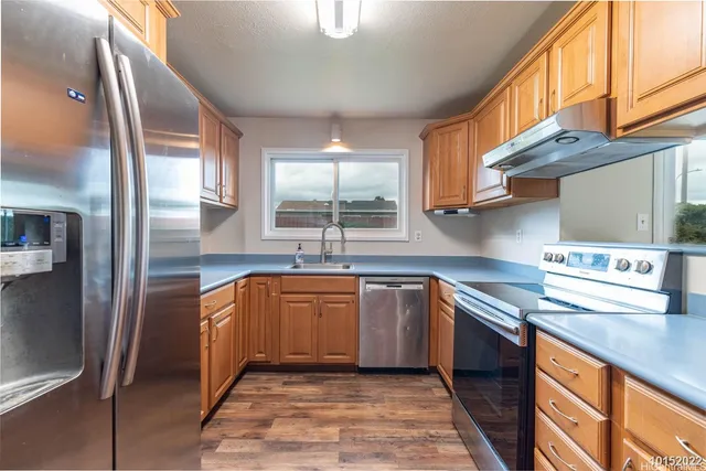 a kitchen with stainless steel appliances granite countertop a sink and a stove