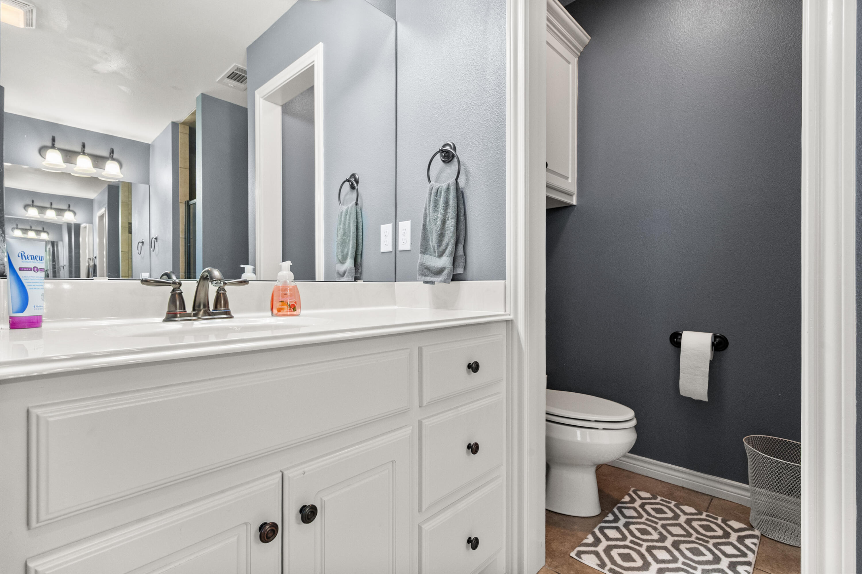 5908 104th Street Lubbock, TX 79424 - Photo 24 of 33 a bathroom with a sink a toilet and a mirror